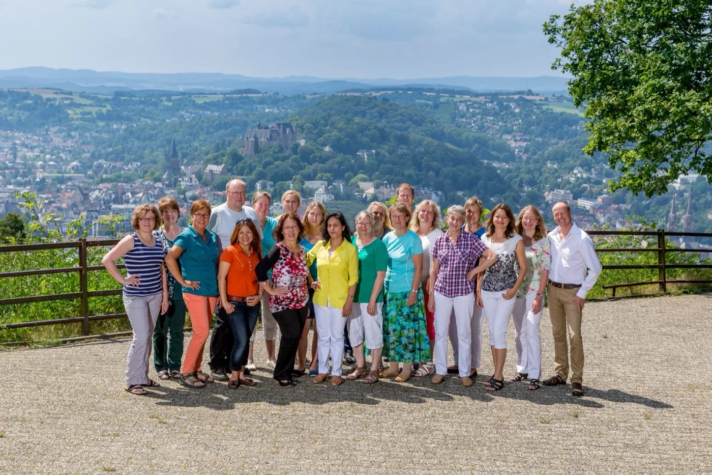 Das Team von MERJE Mobile Pflege auf dem Aussichtspunkt mit Blick auf Marburg und das Schloss